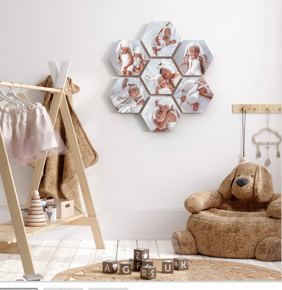 Seven hexagon wooden photo blocks with baby photos arranged on a nursery wall