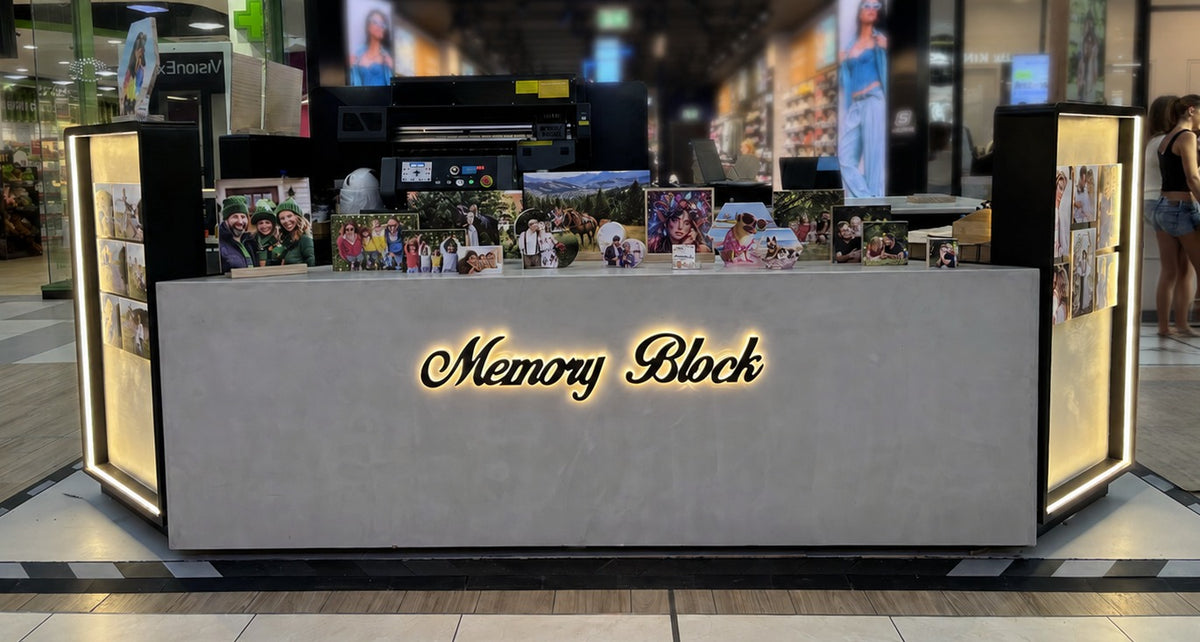 The Memory Block kiosk with its lit sign, where photos are printed onto wood in 5 minutes